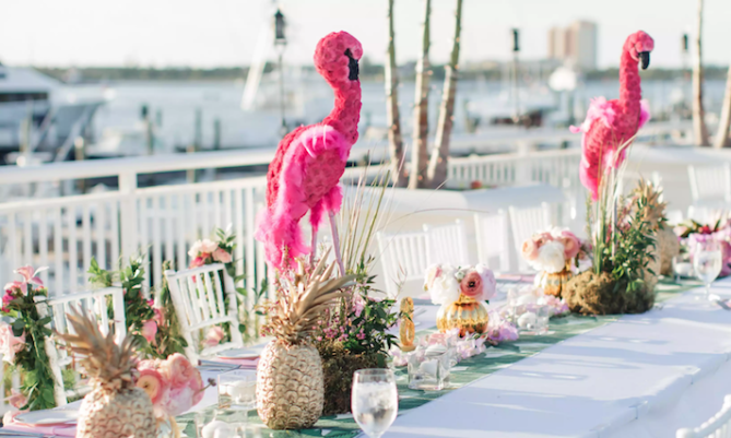 A dining table topped with pineapples and flamingoes