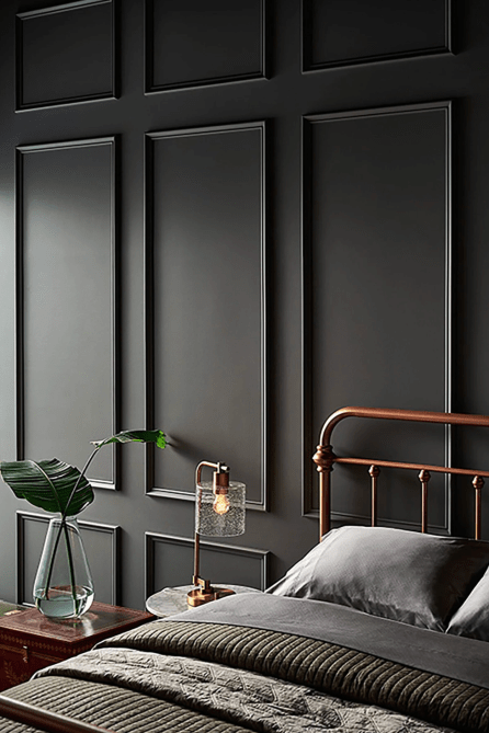 A bedroom with dark gray walls lined with decorative panels