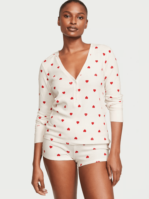 A model wearing a cream pajamas dotted with red hearts