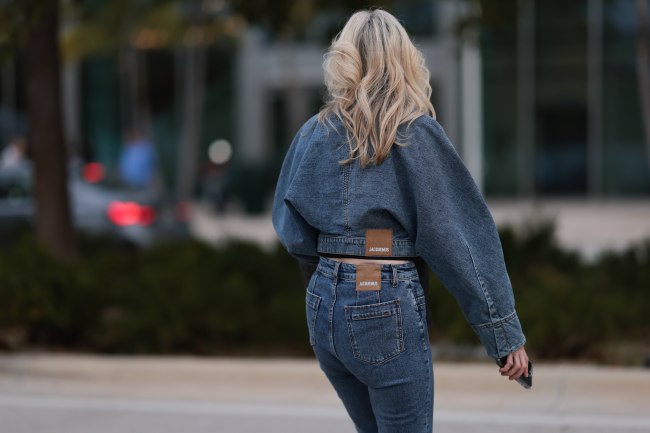 A guest seen wearing Jacquemus dark blue denim two-piece / blue denim oversized jacket with matching blue denim jeans pants, on December 08, 2023 in Miami, Florida.