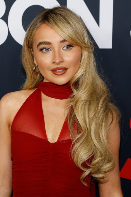 Sabrina Carpenter wearing a red dress with side swept bangs.