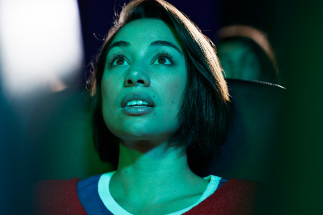 Captivated young woman watching a romance movie at theater