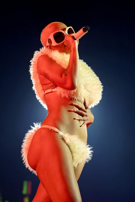 Doja Cat wearing a furry bikini and oversized sunglasses.