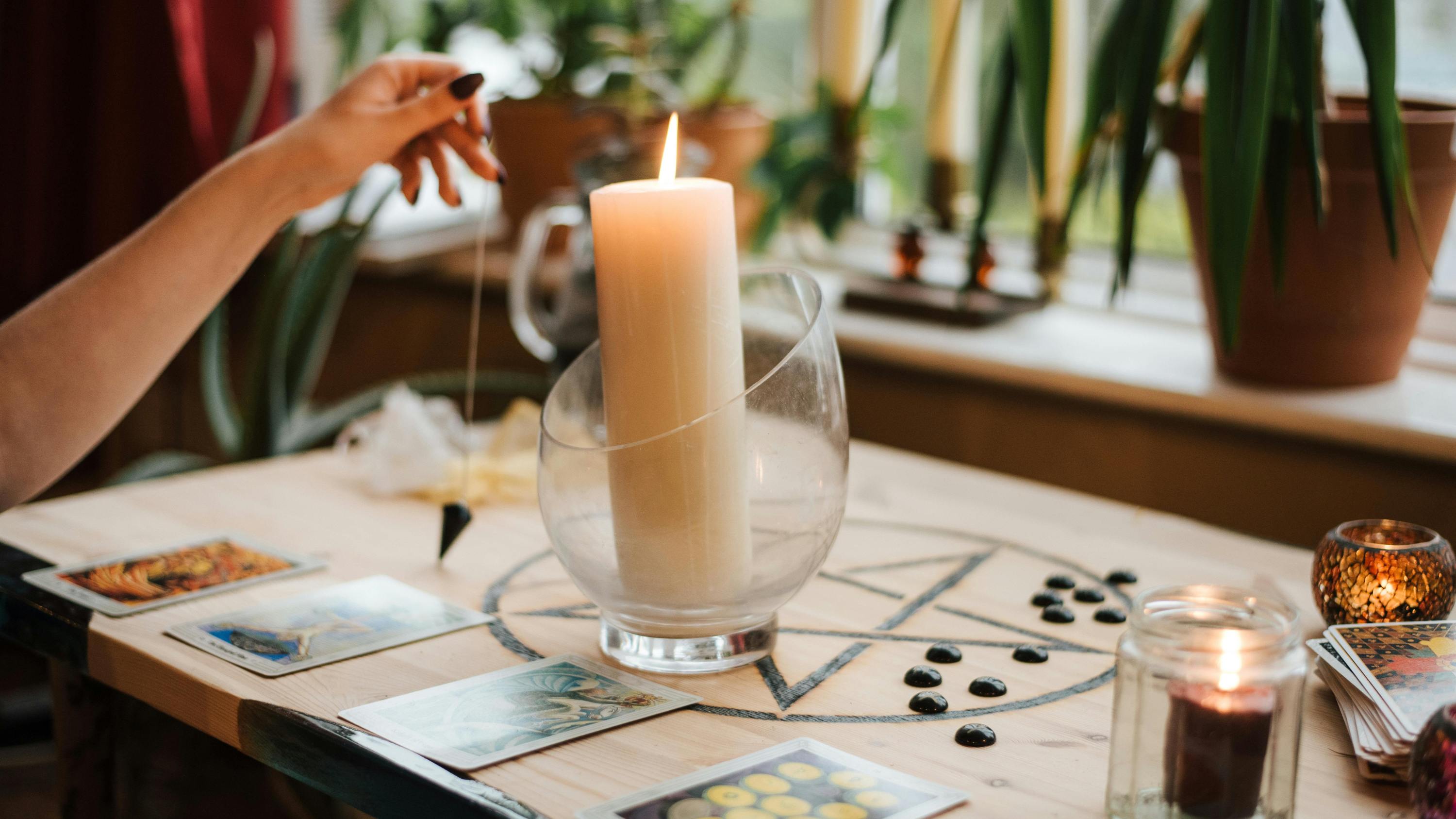 A woman lighting a candle and giving herself a Tarot card reading before the week starts