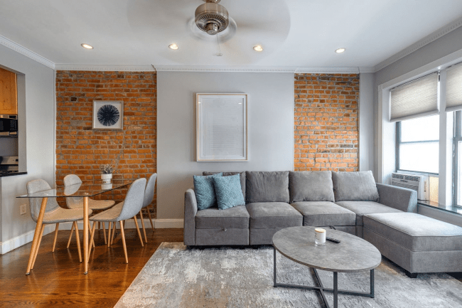 Spacious 3 Bedroom Apartment in New York, New York (Lower East Side) showing the living room couch and dining table.