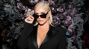 Kesha wearing oversized sunglasses and a blazer.