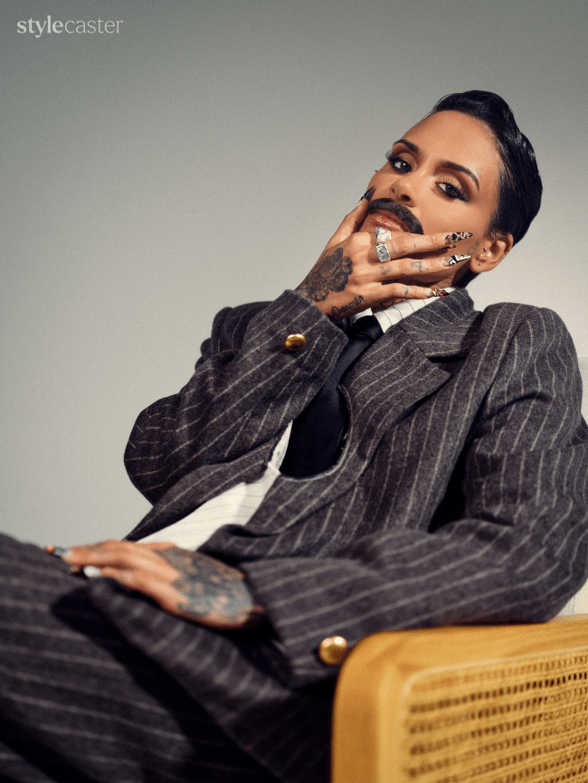 Kehlani holding her face while she's wearing a suit.