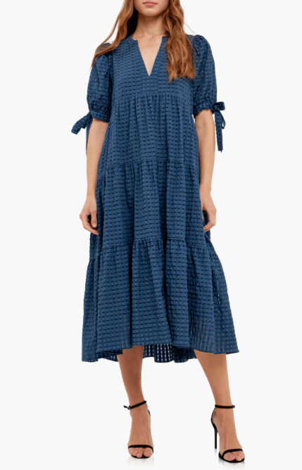 A model wearing the English Factory Gingham Tiered Midi Dress in navy