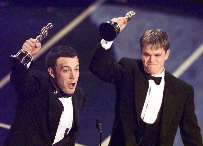Ben Affleck (L) and Matt Damon hold up their Oscars after winning in the Original Screenplay Category during the 70th Academy Awards at the Shrine Auditorium 23 March. The two won for their Original Screenplay "Good Will Hunting."