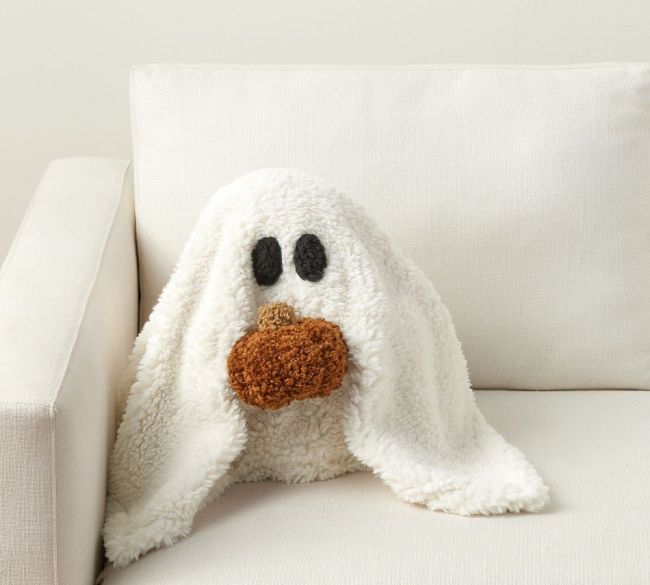 A ghost pillow holding a pumpkin