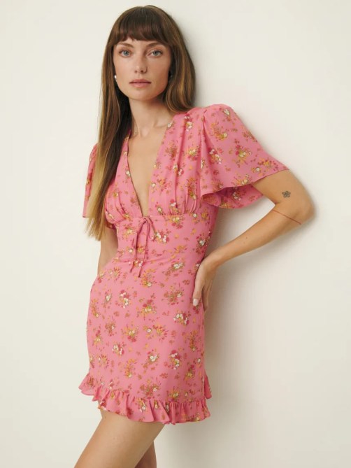 A woman wearing a pink floral dress