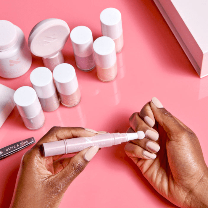 Hand model applying the Olive & June Cuticle Serum