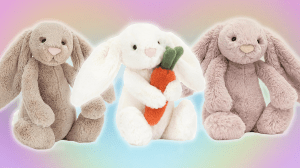 Three Easter bunny Jellycat stuffed animals in a row with a rainbow heart background.
