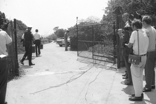Los Angeles, California: Members of the Los Angeles Police Department crime lab pass by newsmen as they go through the gate that leads to the house where a woman, tentatively identified as actress Sharon Tate, and four other persons were found shot to death under bizarre circumstances