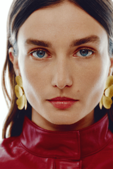 A model wearing the Zara Flower Fan Earrings in Golden colorway