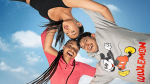 Three models with their arms around each other wearing the Disney x Lululemon collection