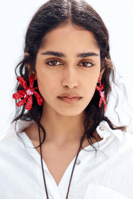 A model wearing the Zara Beaded Combination Flower Earrings in red and pink