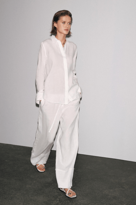 A model wearing the Zara 100% Linen Palazzo Pants in white
