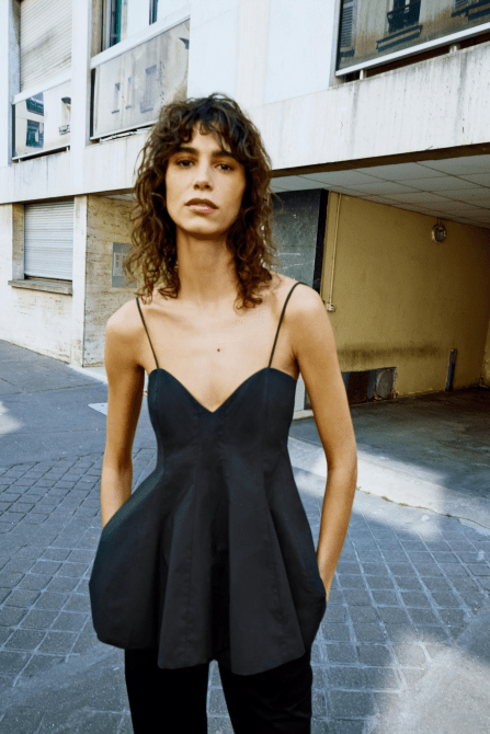 A model wearing the Zara Peplum Top in black