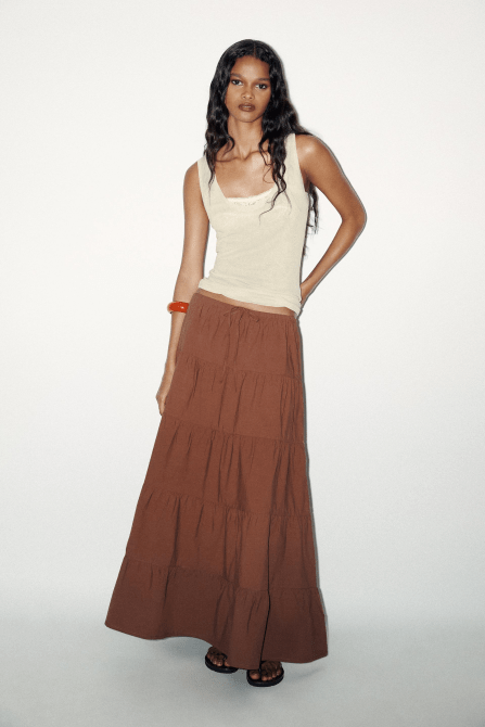 A model wearing the Zara Tiered Maxi Skirt in brown