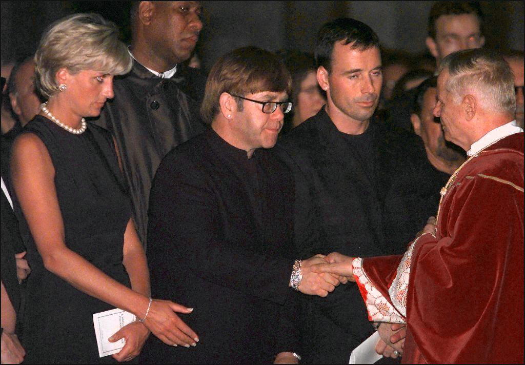 Archpriest Magio (R) shakes hands with British rock star Elton John standing next to Princess Diana (L) during the requiem mass for Italian fashion designer Gianni Versace at the Duomoin Milan 22 July 1997. Versace was gunned down in Miami Beach 15 July. EDS NOTE: Best quality available.