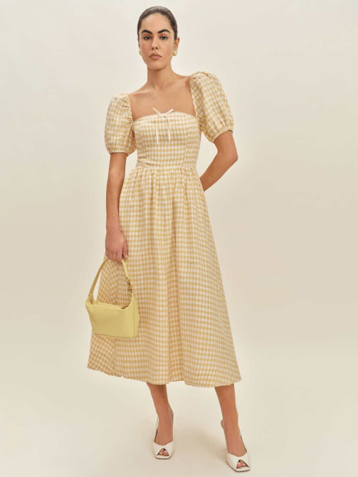 A model wearing Reformation's Marella Linen Dress in a yellow check pattern