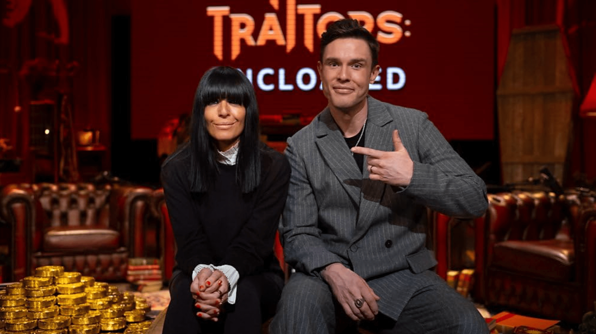 The Traitors host Claudia Winkleman and The Traitors: Uncloaked host Ed Gamble sitting next to each other on set for The Traitors: Uncloaked official visualized podcast